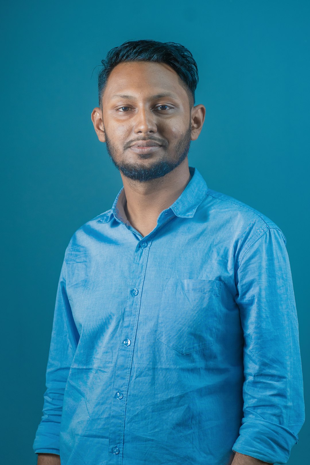 a-man-in-a-blue-shirt-posing-for-a-picture-w4gwd2nlve
