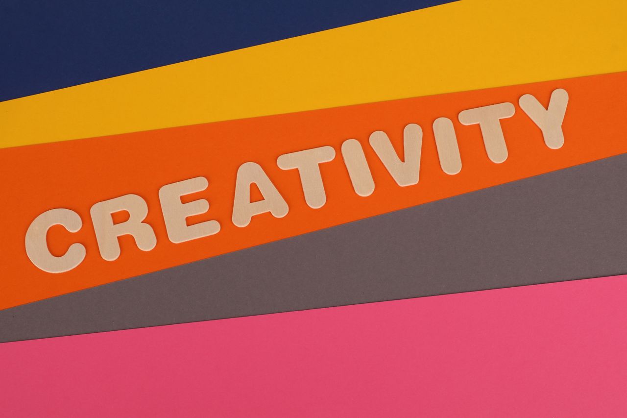 Vibrant layered paper design featuring the word 'Creativity' in bold letters.